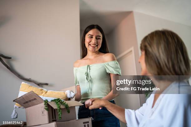 young woman leaving parent's house and getting boxes ready and talking to her parents - belongings 個照片及圖片檔