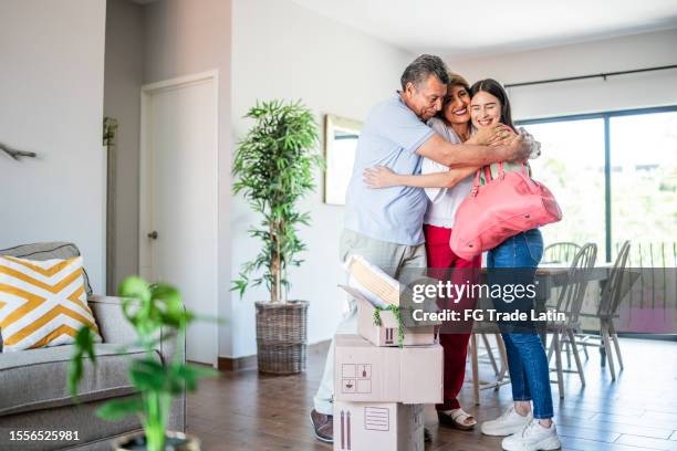 young woman leaving parent's house and they embracing - white van moving stockfoto's en -beelden