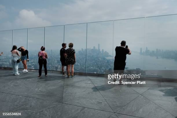 People look out at a hazy Manhattan skyline from an overlook in midtown Manhattan on July 19, 2023 in New York City. An air quality alert remained in...
