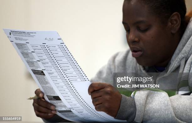 Voter takes a moment to read over her paper ballot before casting her vote at a polling place on the Northside of Chicago, IL, November 6, 2012....