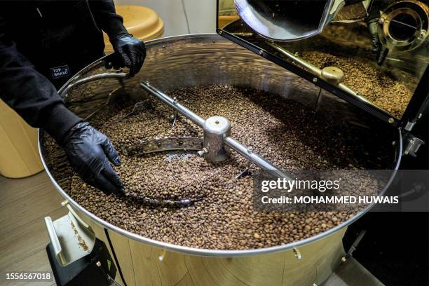 Speciality coffee shop employee operates a coffee roasting machine at the shop in Yemen's Huthi-held capital Sanaa on July 18, 2023. Tucked amid...