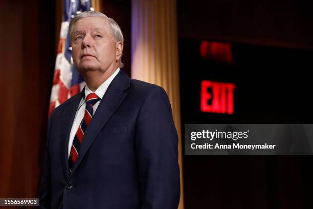 Ranking member Sen. Lindsey Graham listens during a news conference on the U.S. Supreme Court as Sen. Ted Cruz looks on at the U.S. Capitol Building...