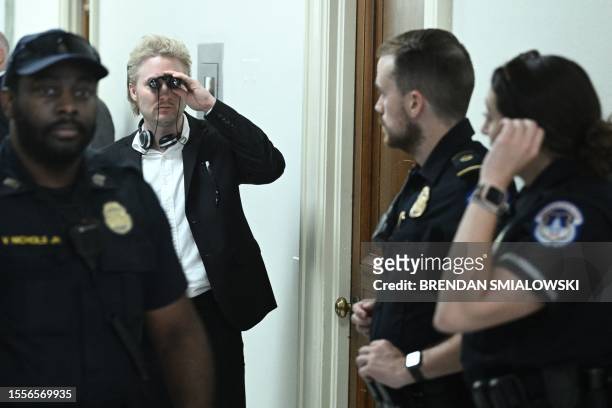 Person looks through binoculars while waiting to attend a House Subcommittee on National Security, the Border, and Foreign Affairs hearing titled...