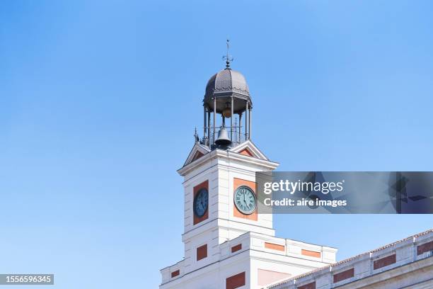 low angle side view of the exterior of the bell tower of the clock in madrid spain with the sky in the background - puerta de sol stock-fotos und bilder