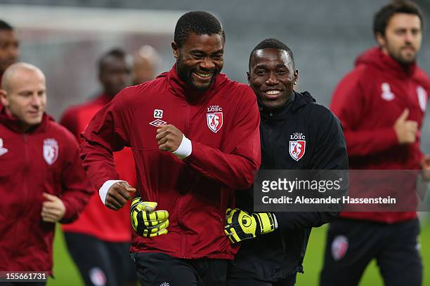 Aurelien Chedjou smiles with his team mate Barel Mouko during a OSC Lille training session ahead of their UEFA Champions League group F match against...