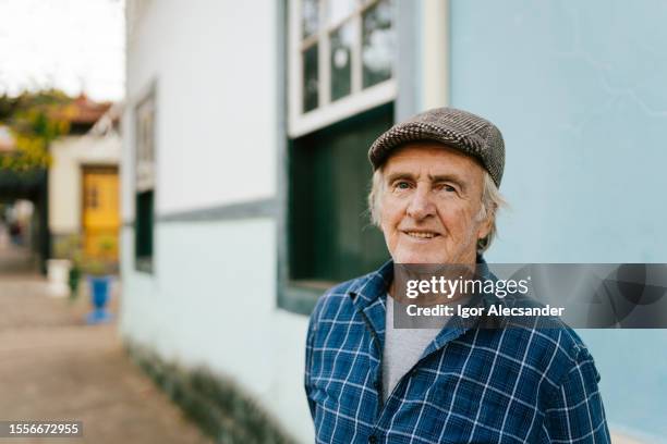 anciano en un pequeño pueblo - gorra plana fotografías e imágenes de stock