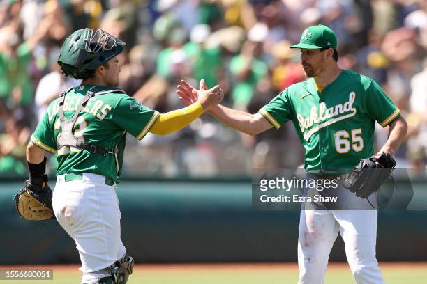 Shea Langeliers shakes hands with Trevor May of the Oakland Athletics after they beat the Boston Red Sox at RingCentral Coliseum on July 19, 2023 in...
