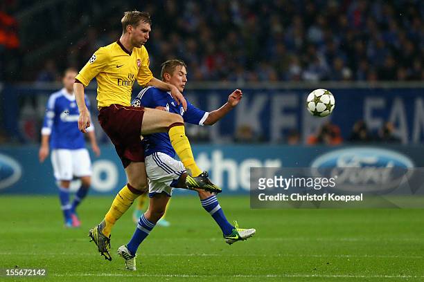Per Mertesacker of Arsenal challenges Lewis Holtby of Schalke during the UEFA Champions League group B match between FC Schalke 04 and Arsenal FC at...