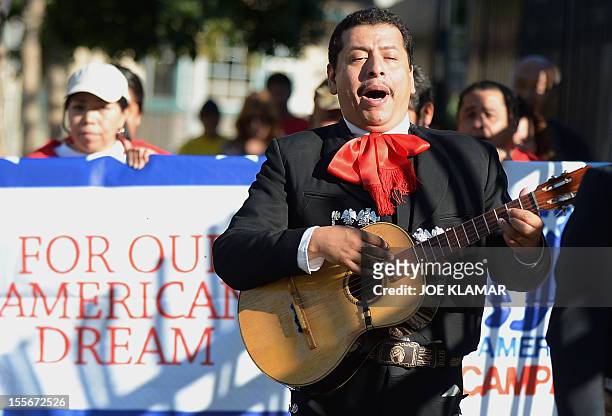 Mariachi musicians sing and play serenadas as they go from house to house to encourage people to come to vote on election day in the predominantly...