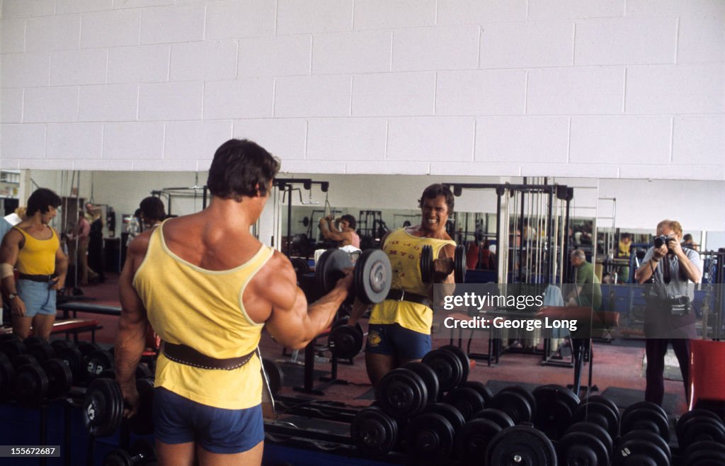 View of bodybuilder Arnold Schwarzenegger lifting weight during... News