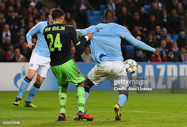 Mario Balotelli of Manchester City has his shirt pulled by Ricardo van Rhijn of Ajax in the penalty box during the UEFA Champions League Group D...