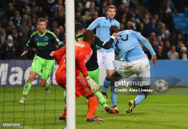 Mario Balotelli of Manchester City has his shirt pulled by Ricardo van Rhijn of Ajax in the penalty box during the UEFA Champions League Group D...