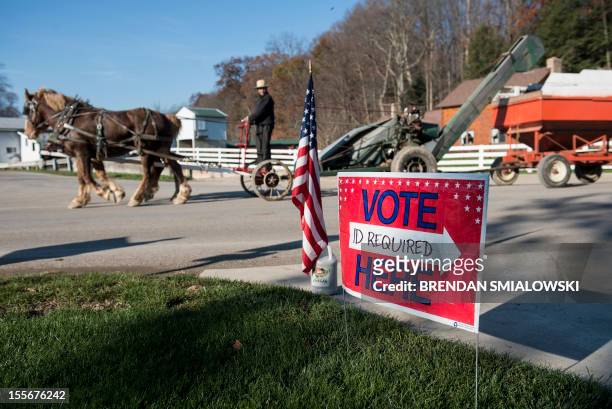 Man moving farm equipment passes Beck's Mill General Store and polling station during election day on November 6, 2012 in Becks Mill, Ohio. Citizens...