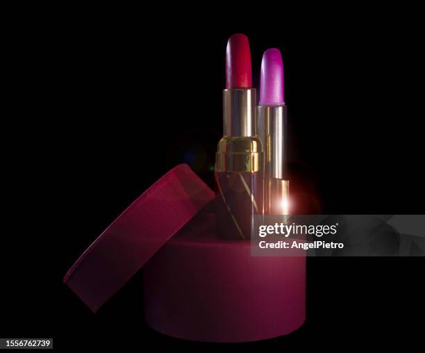 a pair of lipsticks on a black background. - beauty cosmetic luxury studio background stock-fotos und bilder