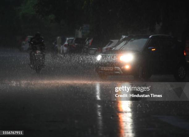 Commuters seen out during heavy rain in Sector 12 road, on July 26, 2023 in Noida, India. The residents of Delhi-NCR witnessed heavy rainfall....