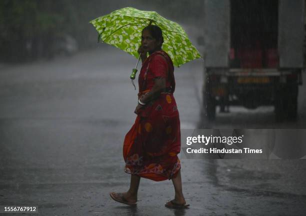 Commuters seen out during heavy rain in Sector 12 road, on July 26, 2023 in Noida, India. The residents of Delhi-NCR witnessed heavy rainfall....