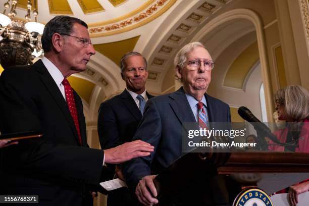 Sen. John Barrasso reaches out to help Senate Minority Leader Mitch McConnell after McConnell froze and stopped talking at the microphones during a...