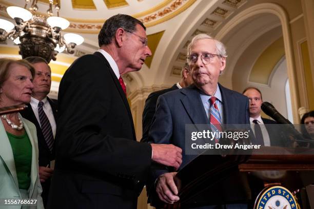 Sen. John Barrasso reaches out to help Senate Minority Leader Mitch McConnell after McConnell froze and stopped talking at the microphones during a...