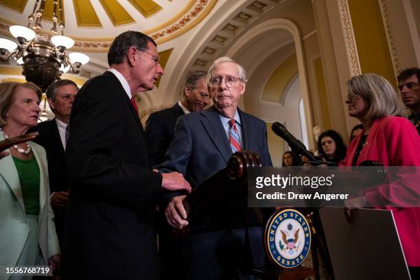 Sen. John Barrasso reaches out to help Senate Minority Leader Mitch McConnell after McConnell froze and stopped talking at the microphones during a...