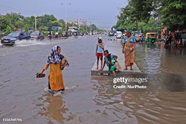 Locals wades through a waterlogged road following monsoon rainfall, near JLN Marg in Jaipur, Rajasthan, India, Wednesday, on July 26, 2023.