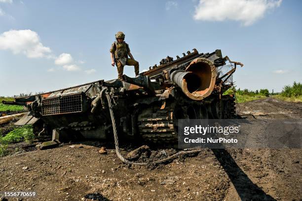 Press officer who goes by callsign Damian stands on top of a destroyed Russian military vehicle in Novodarivka village, Zaporizhzhia Region,...