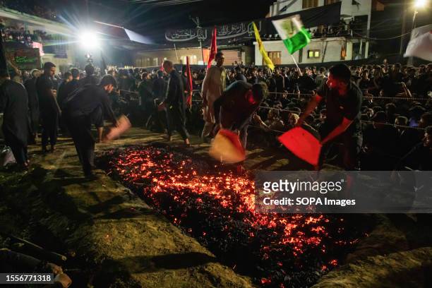 Kashmiri Shiite Muslim men prepare fire pit to take part in fire walking ceremony during the commemorations of the Ashura , in the outskirts of...