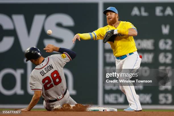 Justin Turner of the Boston Red Sox turns a double play over Matt Olson of the Atlanta Braves during the fourth inning at Fenway Park on July 26,...