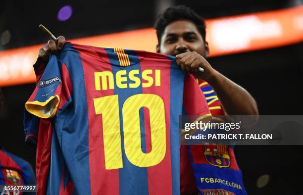 Barcelona fan waves a Messi jersey ahead of a pre-season friendly football match between Arsenal FC and FC Barcelona at SoFi Stadium in Inglewood,...