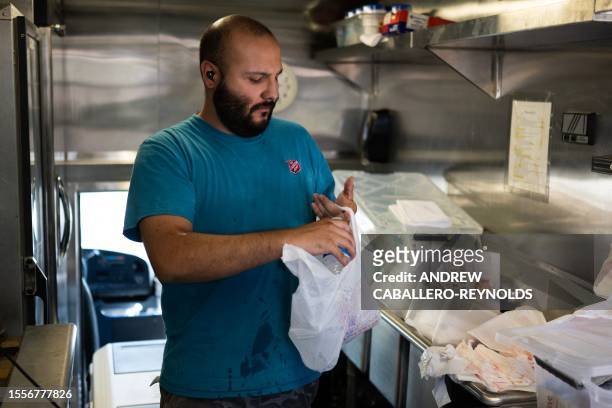 David Valdez packs water for those in need in a Salvation Army truck handing out water, and other supplies for the homeless in Tucson, Arizona on...