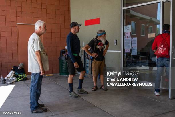 People wait to enter a Salvation Army cooling center for the homeless in Tucson, Arizona on July 26, 2023. A record-breaking heat wave stretching...