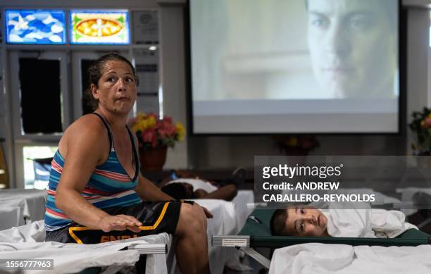 Nathaniel and his mother Jennifer, look up as they rest on cots at a Salvation Army cooling center for the homeless in Tucson, Arizona on July 26,...