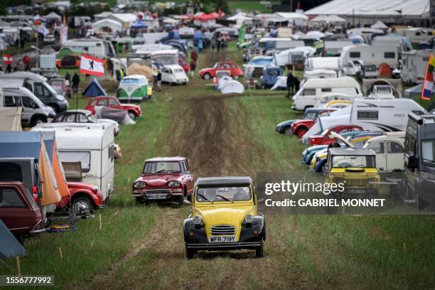 Cars drive through the camp during the 24th World meeting of Citroen 2CV friends near Delemont, northern Switzerland on July 26, 2023. Archetypal...
