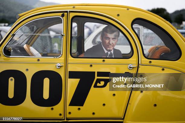 Car adorned with fictional cinema character "James Bond" themed decoration sits parked in a field during the 24th World meeting of Citroen 2CV...