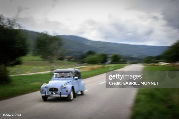 Car drives to the 24th World meeting of Citroen 2CV friends near Delemont, northern Switzerland on July 26, 2023. Archetypal French car, the 2CV ,...