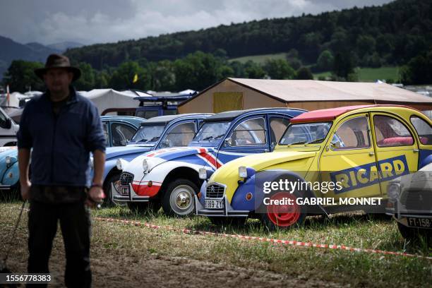 Cars are parked, lined up in a field during the 24th World meeting of Citroen 2CV friends near Delemont, northern Switzerland on July 26, 2023....
