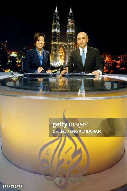Al-Jazeera news anchors Veronica Pedrosa and Teymoor Nabili pose for photographs on set at the Al Jazeera broadcast centre in Kuala Lumpur, 21...