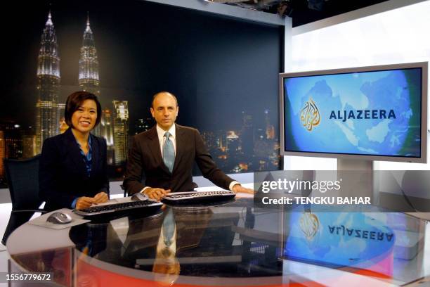 Al-Jazeera news anchors Veronica Pedrosa and Teymoor Nabili pose for photographs on set at the Al-Jazeera broadcast centre in Kuala Lumpur, 21...