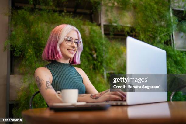 woman with tattoo and pink hair working at cafe - hair dye stock pictures, royalty-free photos & images