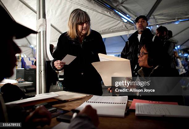 People vote in the presidential elections in a tent in the Midland Beach neighborhood of Staten Island on November 6, 2012 in New York City. As...