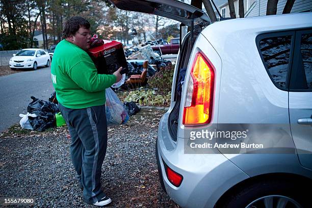 Tim Dunston helps load a friend's car with luggage while evacuating due to an approaching storm on November 6, 2012 in Brick Township, New Jersey. As...
