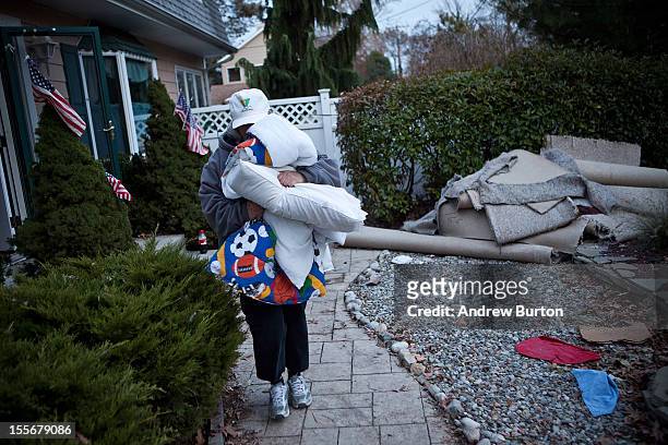 Trisha McAvoy carries bedding to her car while evacuating from her home due to an approaching storm on November 6, 2012 in Brick Township, New...