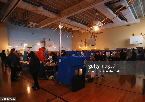 People vote at Public School to under lightning provided by gas powered generators on November 6, 2012 in Oceanside, New York. Many voters in New...