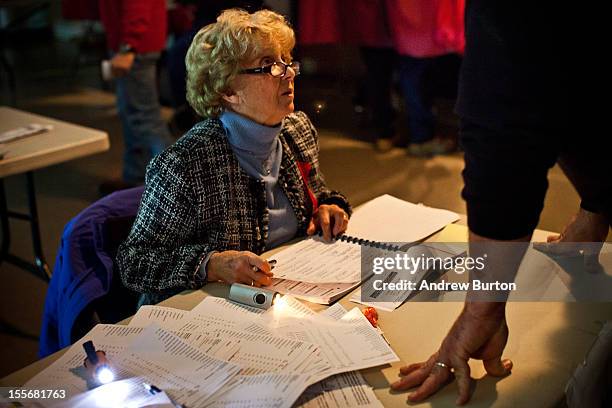 Poll worker checks in a vote, by the light of generators, at Silver Bay Elementary School on November 6, 2012 in Toms River, United States. The...