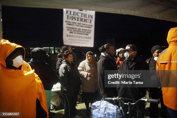 Rockaway residents wait in line to cast their ballots in an unheated makeshift tent set up as a polling place at Scholars' Academy, PS 180, in the...