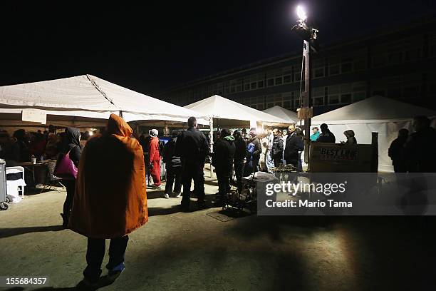 Rockaway residents wait in line to cast their ballots in an unheated makeshift tent set up as a polling place at Scholars' Academy, PS 180, in the...