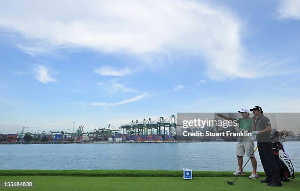 Rory McIlroy of Northern Ireland ponders his club selection with caddie J.P Fritzgerald, as he leans on his Titleist bag during the pro - am prior to...