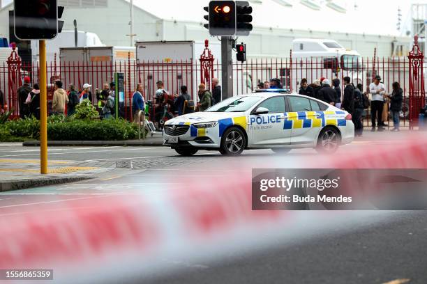 Police vehicles are seen near the location of a reported shooting on July 20, 2023 in Auckland, New Zealand. A gunman and two others others were...