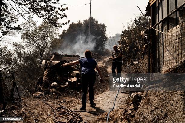 People try to put out the fire by themselves in Cardeto, Reggio Calabria, Italy on July 25, 2023.