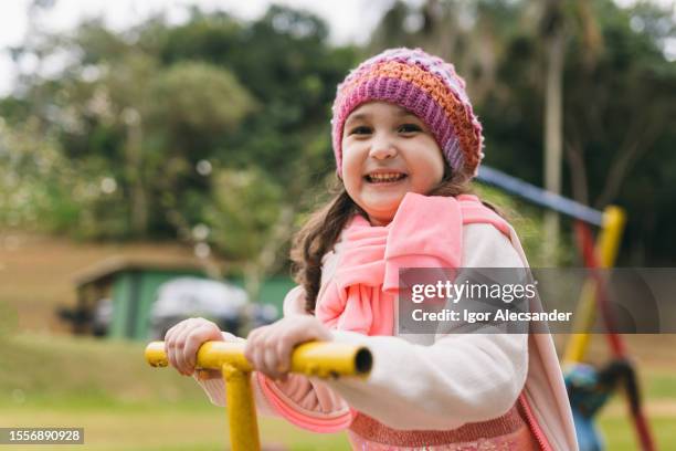 little girl having fun on the playground - warm clothing stock pictures, royalty-free photos & images