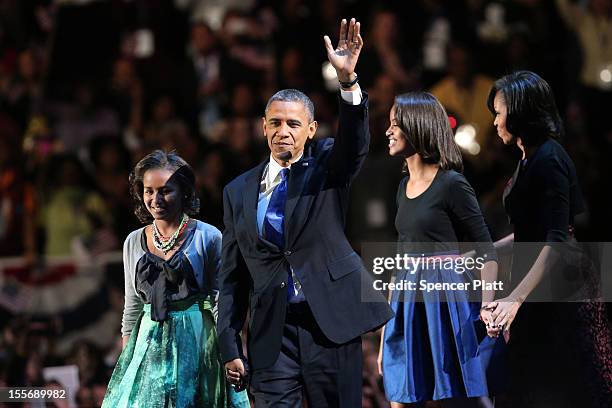 President Barack Obama walks on stage with first lady Michelle Obama and daughters Sasha and Malia to deliver his victory speech on election night at...